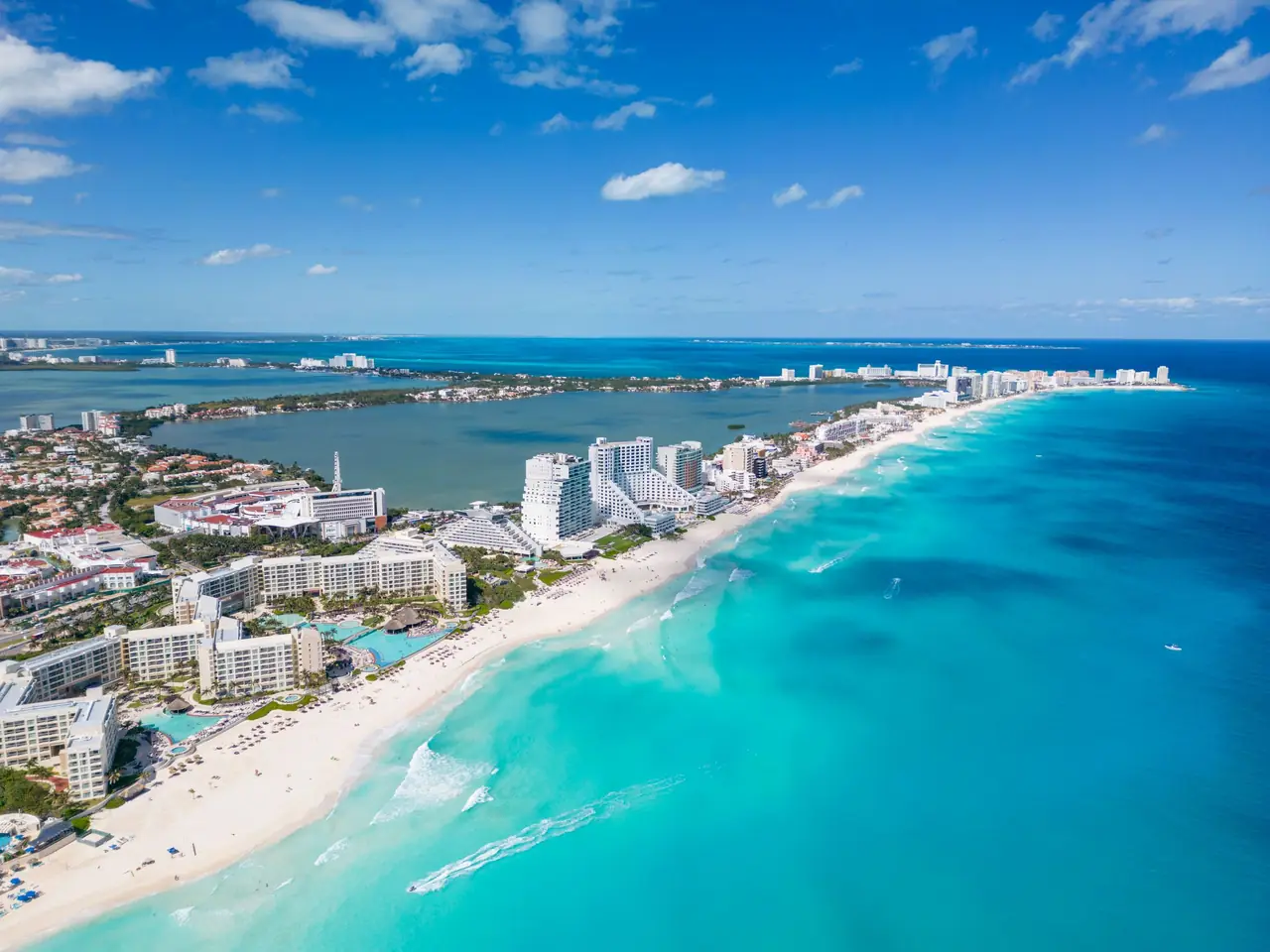 Aerial view of the Cancun Hotel Zone, a strip of beachfront resorts between turquoise Caribbean water and Nichupte Lagoon