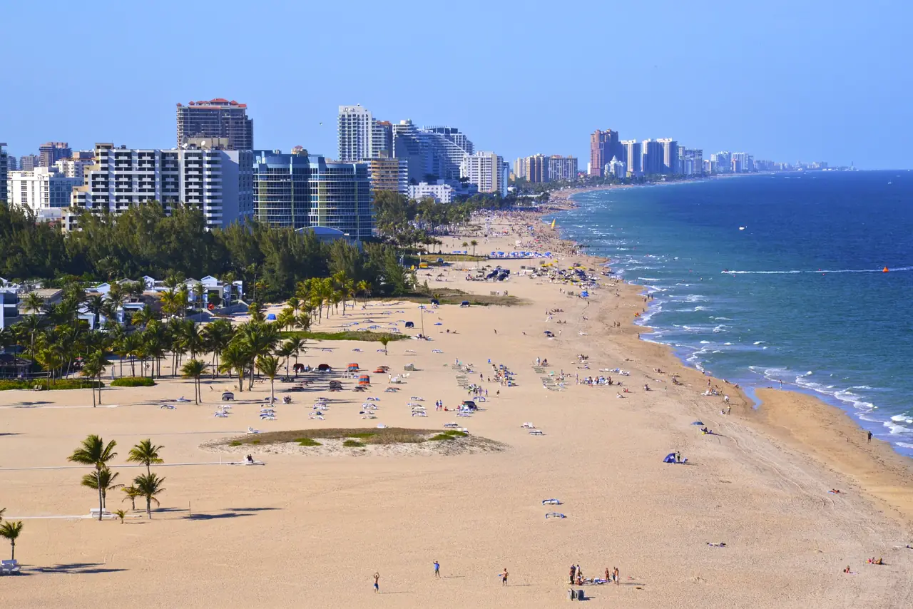 Fort Lauderdale Beach with palm trees, wide sand and high-rise condos lining the Atlantic shore