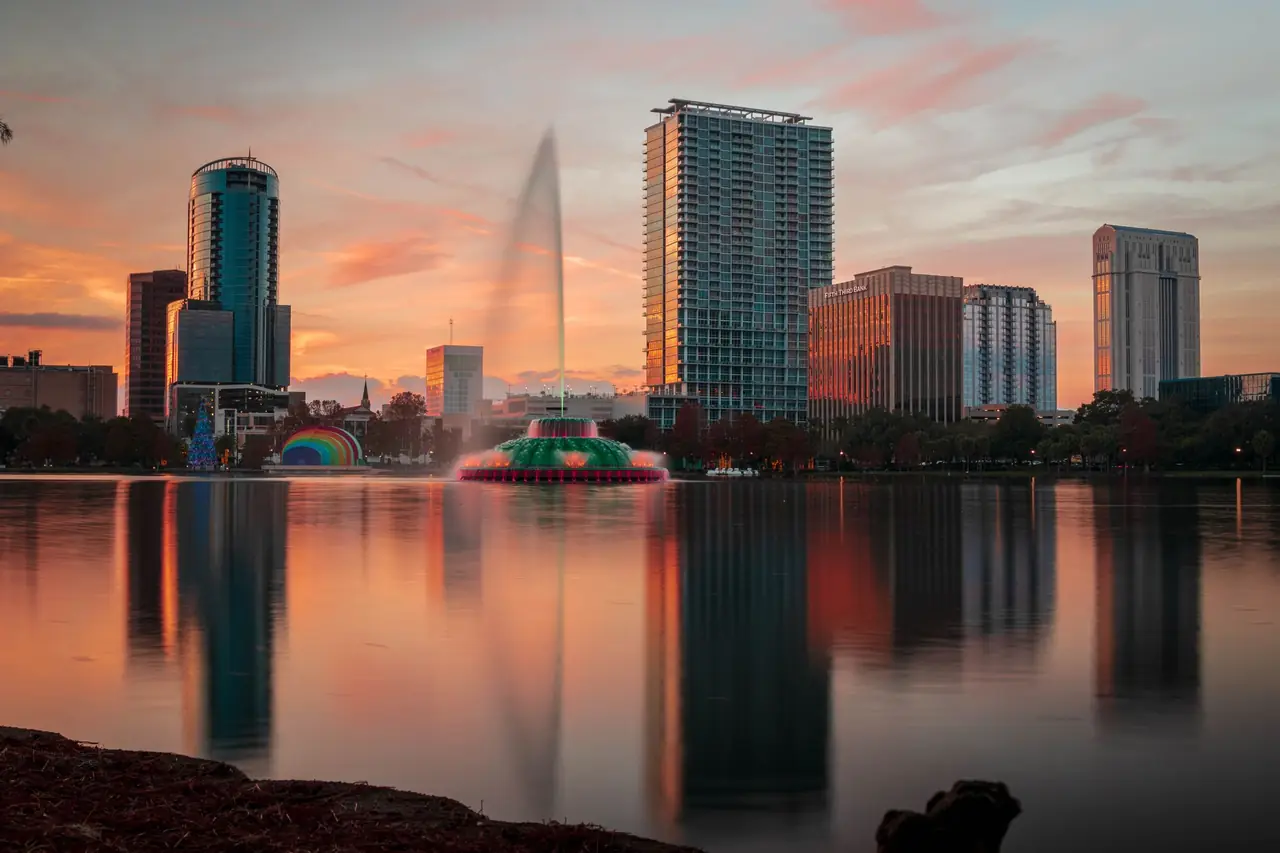 Lake Eola fountain and the downtown Orlando skyline reflected in the lake at sunset