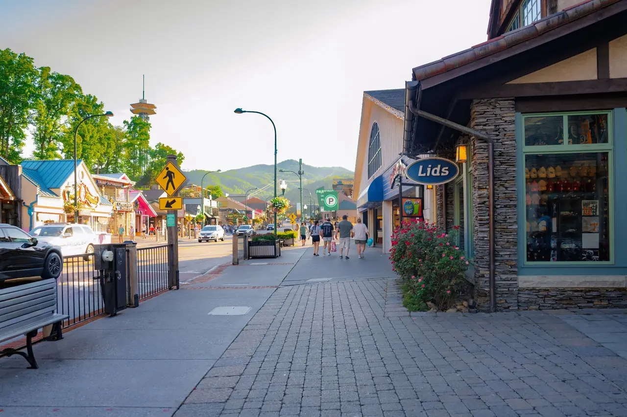 Shops along the Parkway in downtown Gatlinburg, with the Gatlinburg Space Needle and green mountains beyond