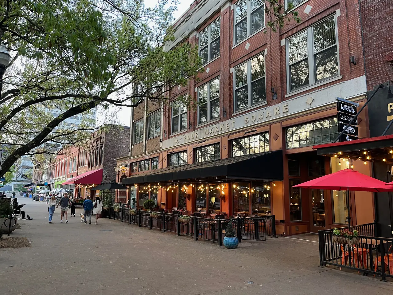 Restaurant patios and string lights along Knoxville's Market Square beneath the Four Market Square building